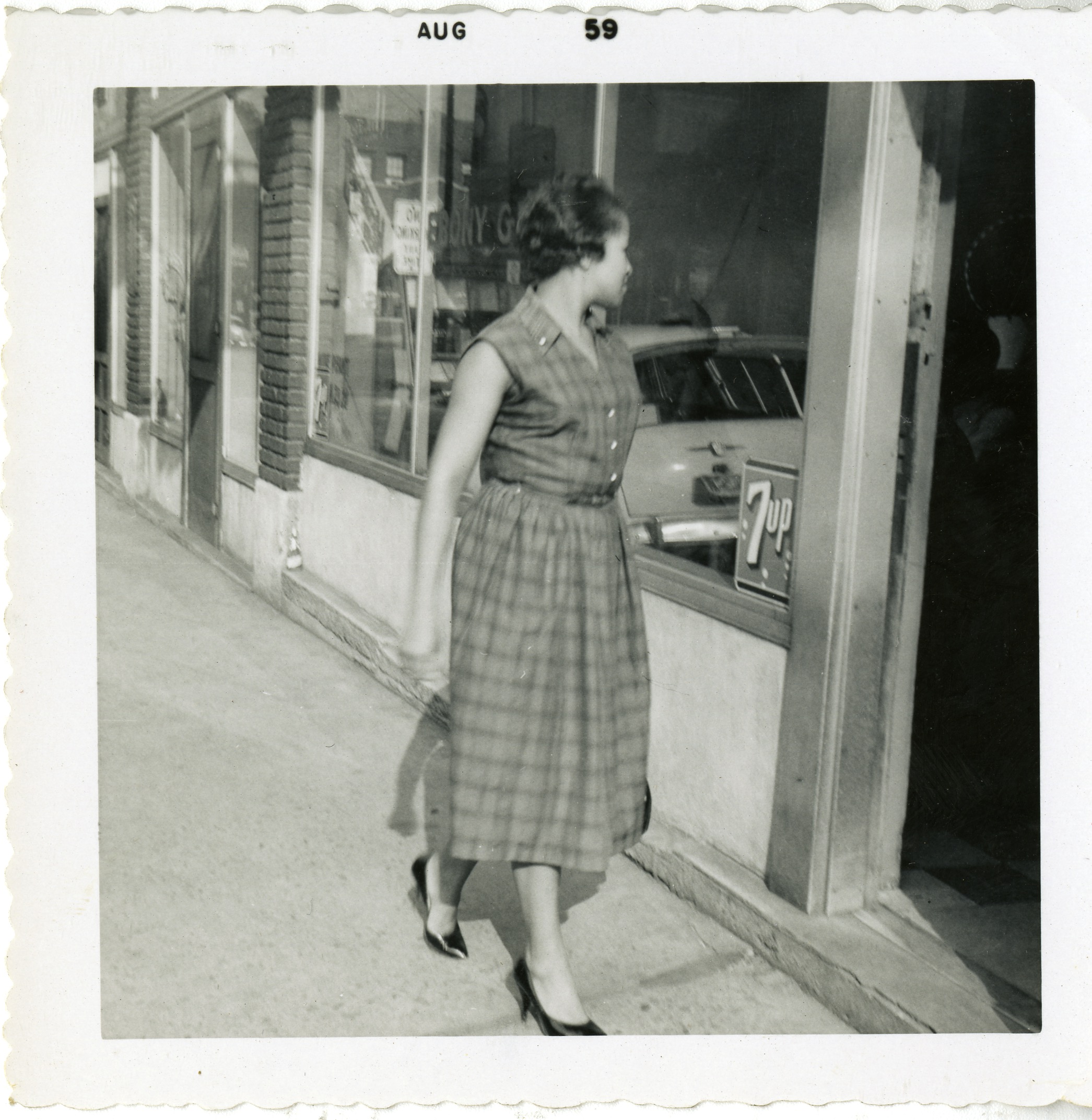 Woman walking in front of the Ebony Grill located at 19 Eagle Street, 1959