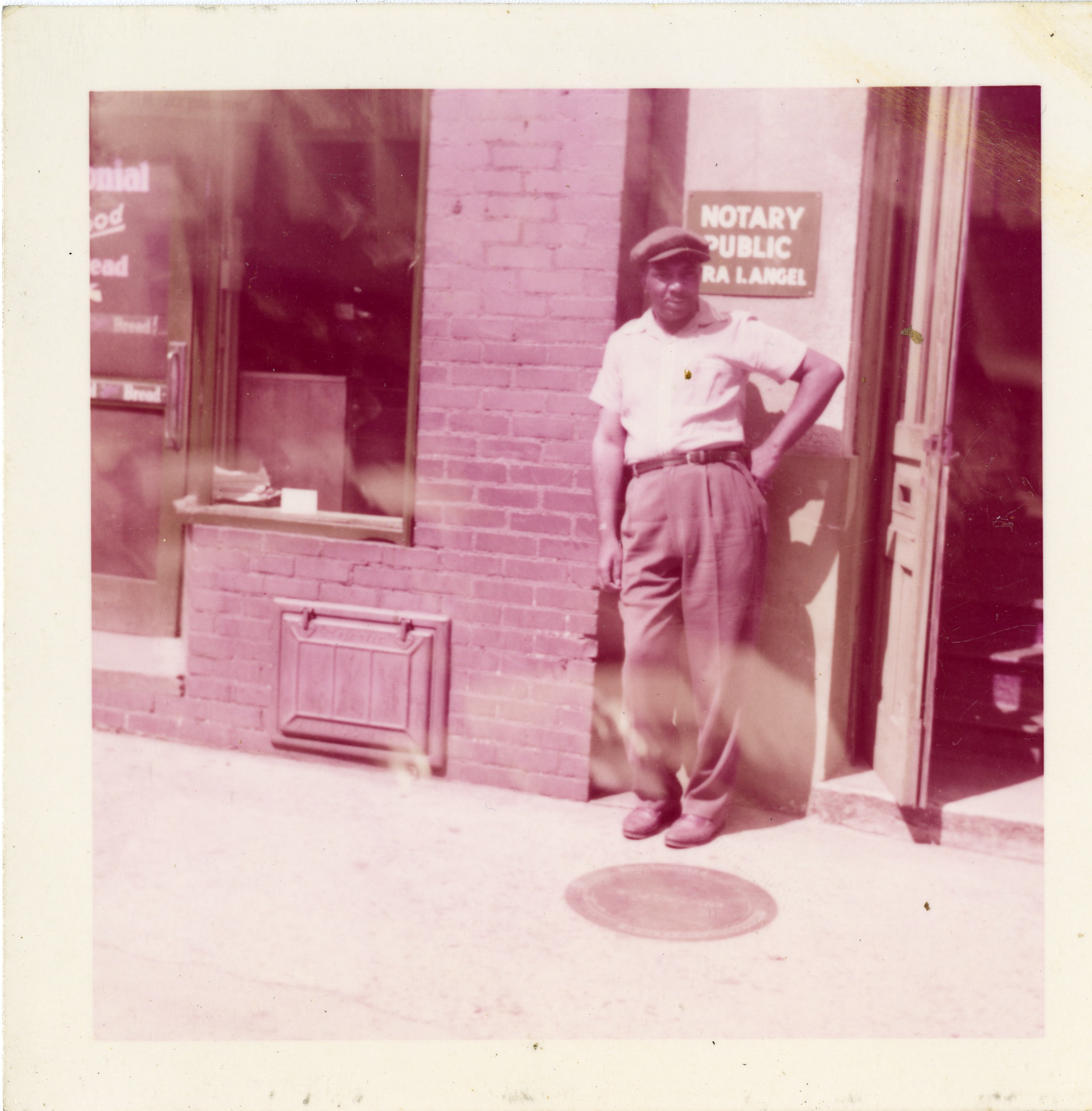 Man in front of sign for Ira I. Angel, Notary Public