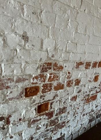 White brick wall with red scrapes