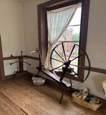 A spinning wheel set next to an open window