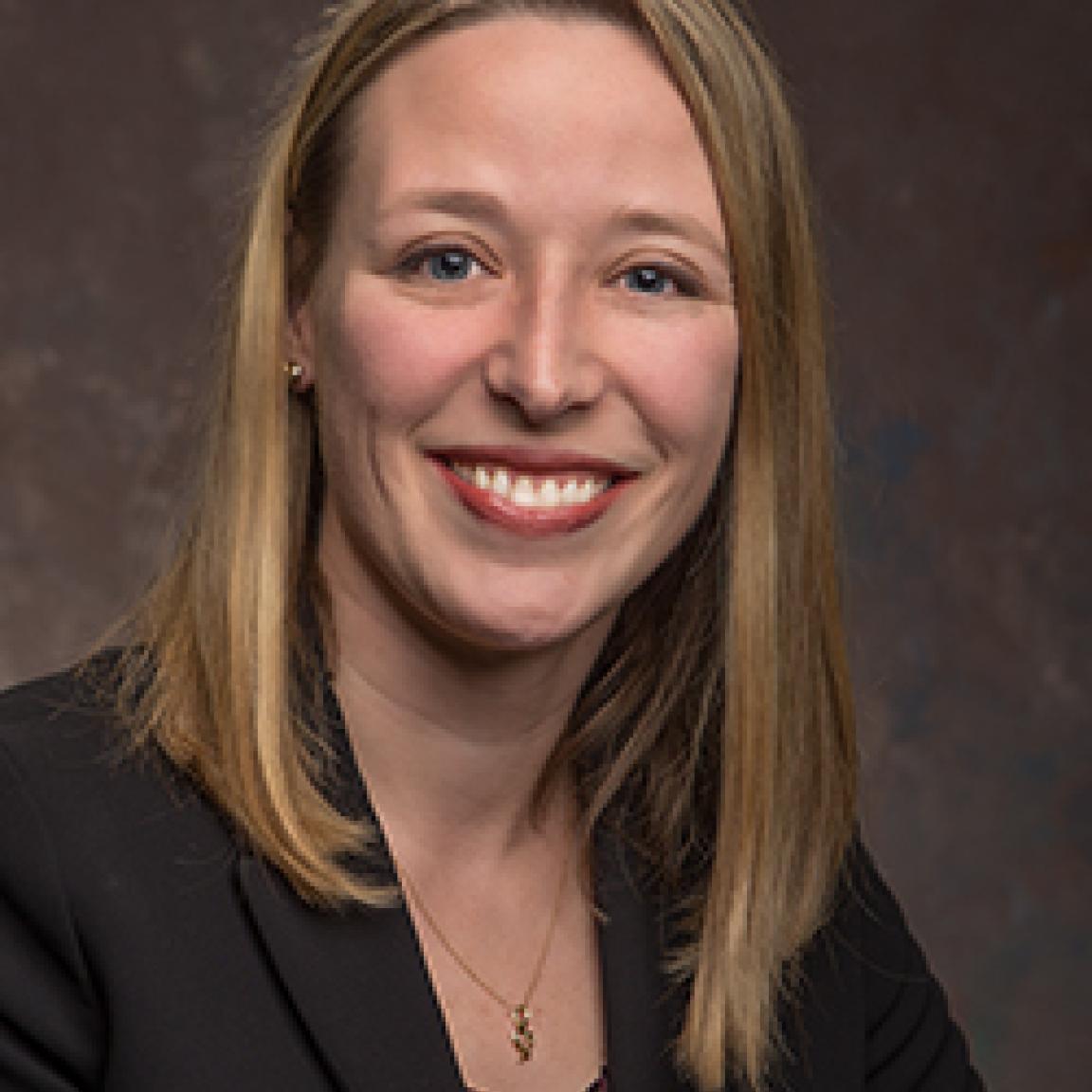 Katherine Bosken, NC ABLE Board member, professional headshot in business attire on a dark background
