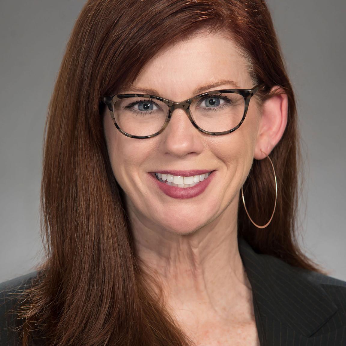 Melinda Plue, NC ABLE Board member, in a professional headshot with a light studio background