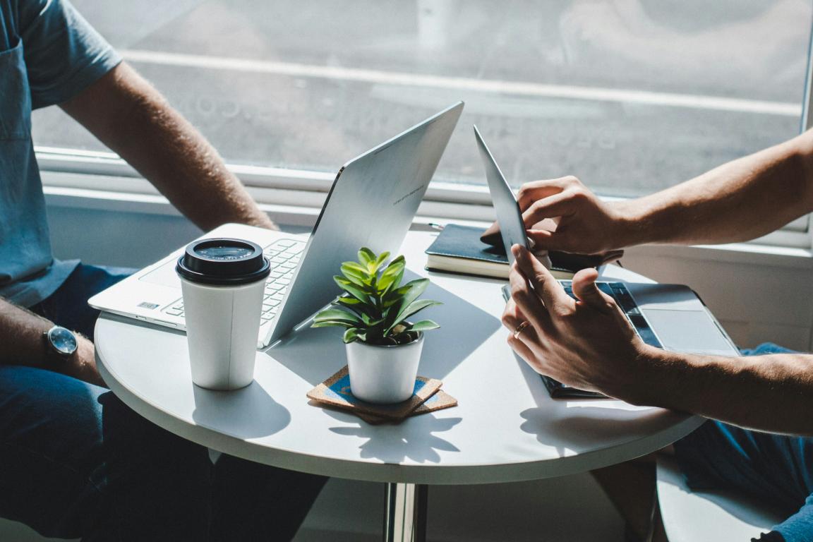 Two computers sit on a table, indicating a meeting. 