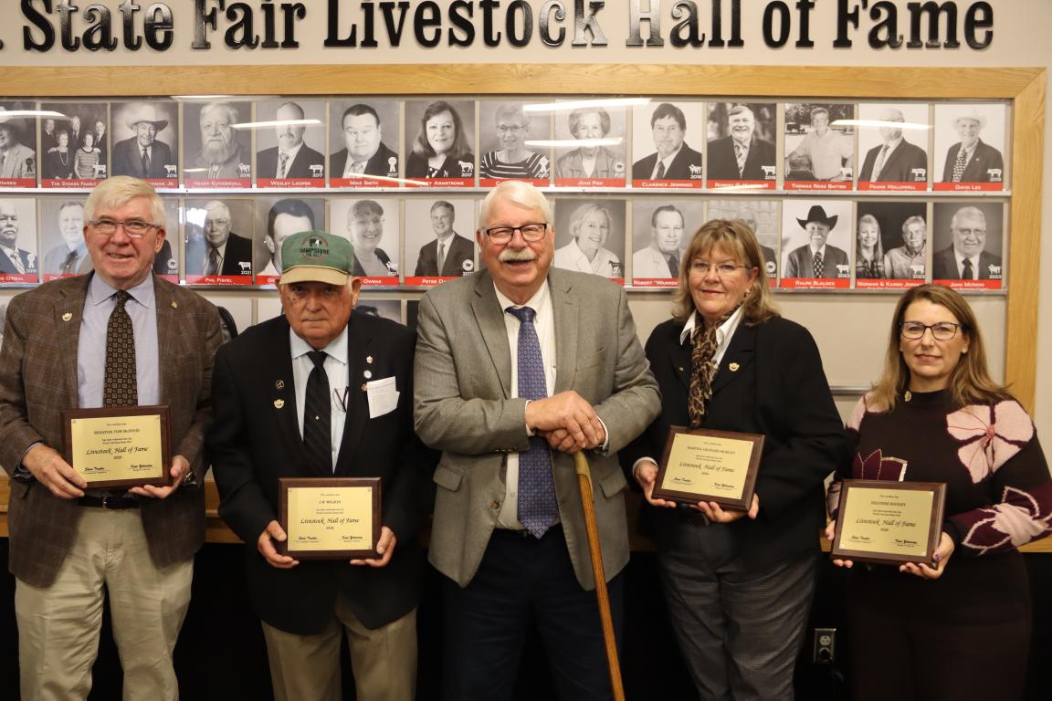 Three men and two women pose for a photo at the induction ceremony.