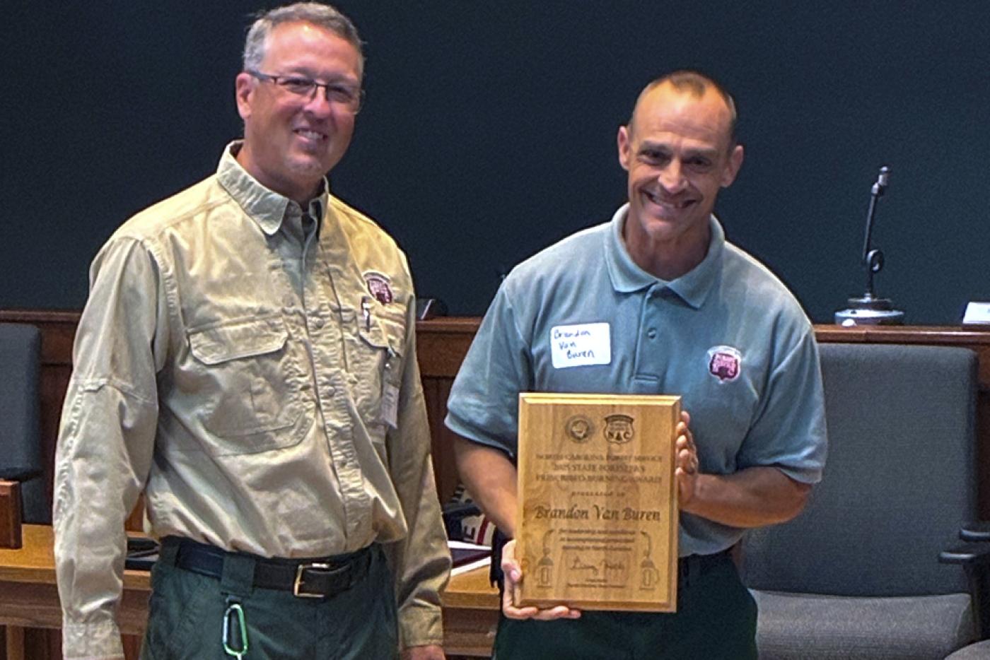 State Forester Greg Hicks presents Brandon Van Buren, NCFS Richmond County ranger, with the State Forester's Prescribed Burning Award