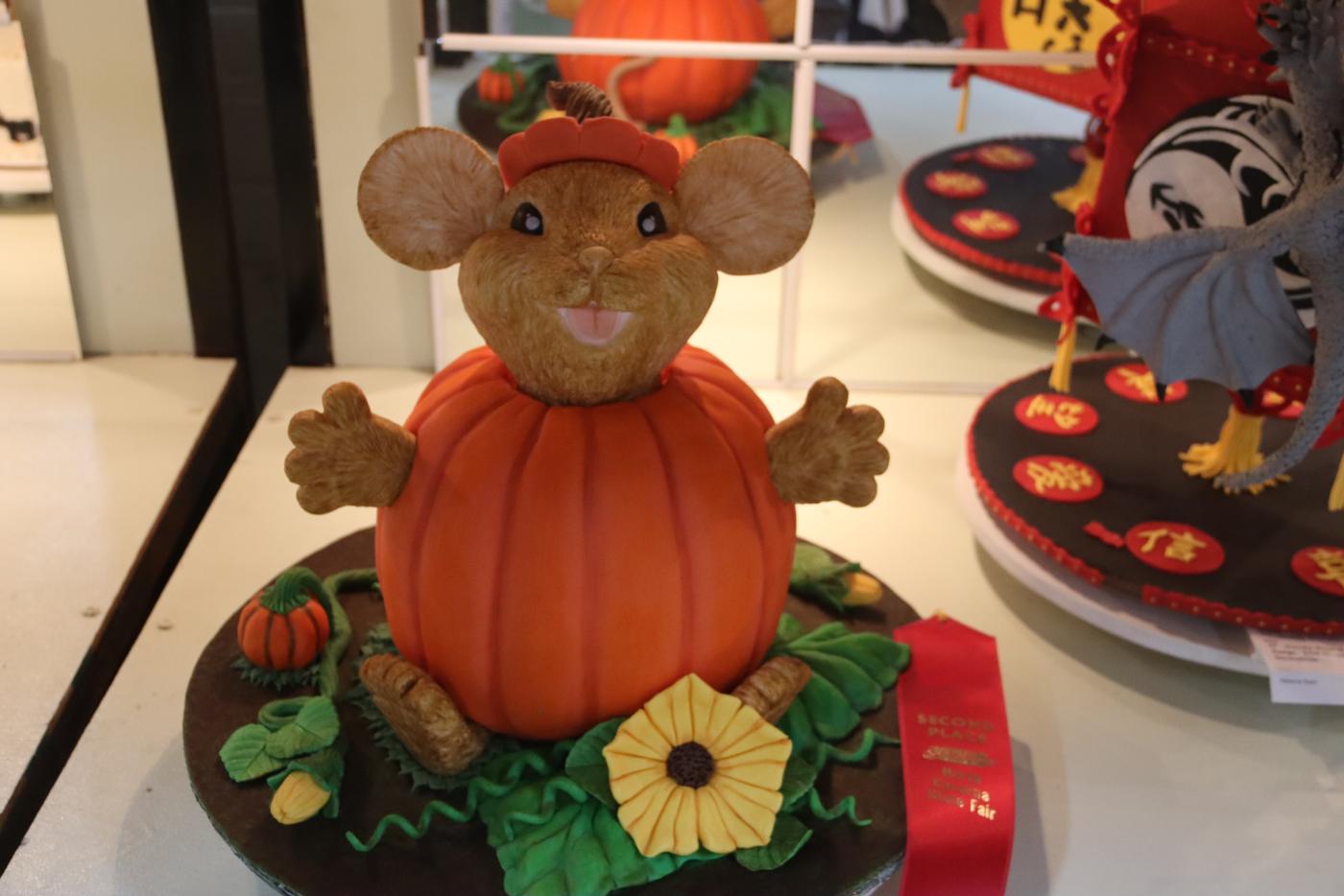 mouse in pumpkin shaped cake with a red ribbon 