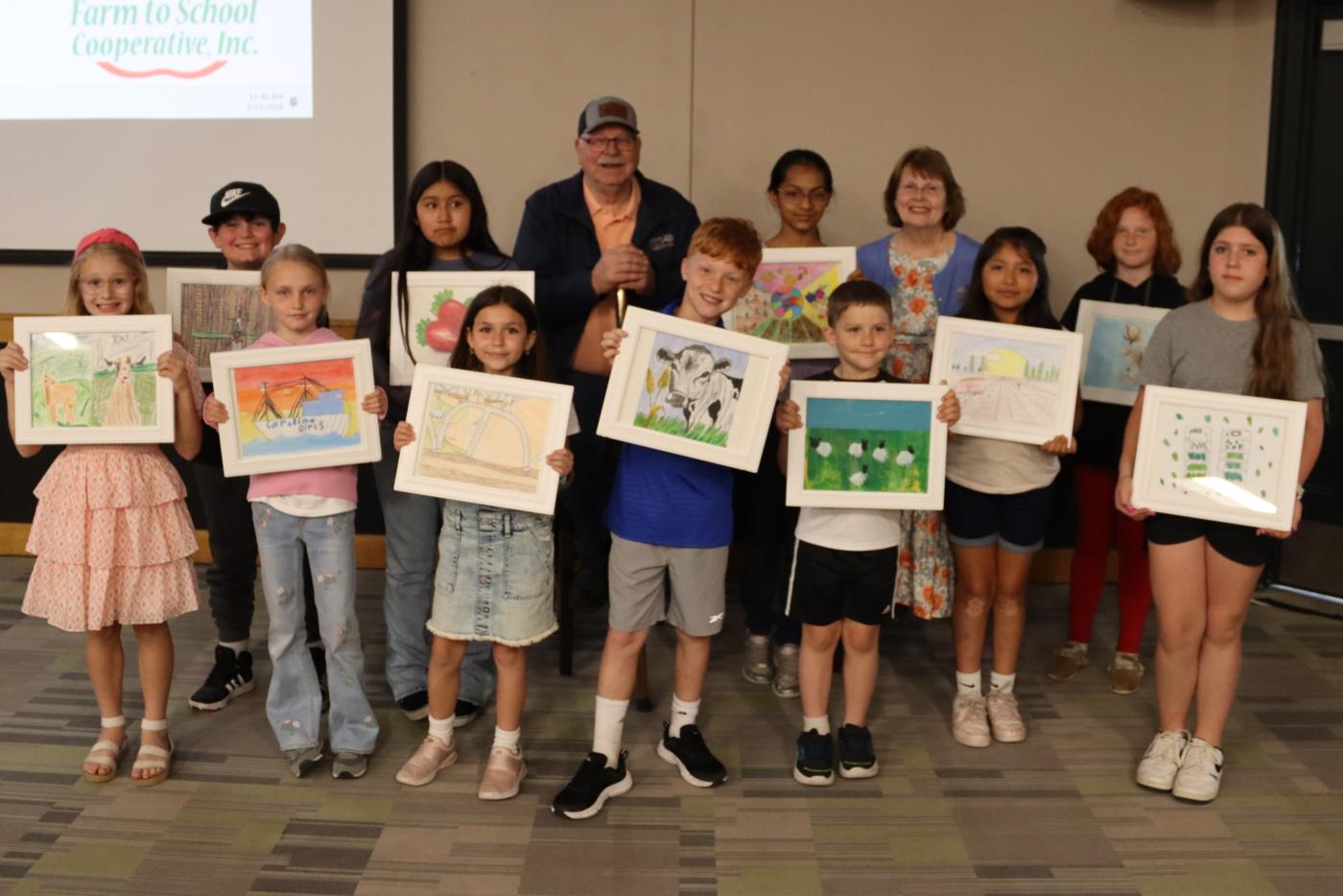 school age children holding artwork with Commissioner Steve Troxler 