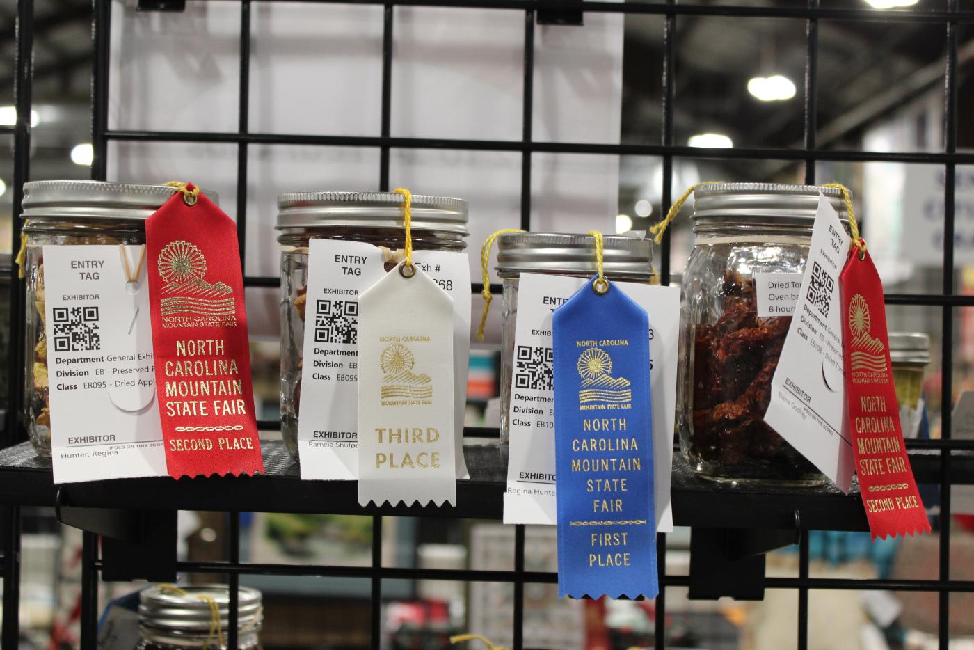 A row of dried canned goods that won red, white and blue ribbons.