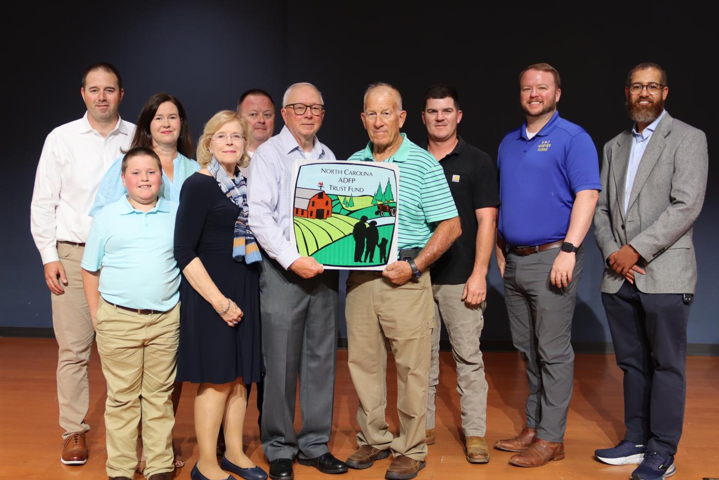 A group of people pose for a photo on a stage.