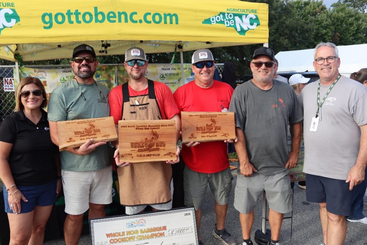 Top three winners in the Got to Be NC Whole Hog BBQ Cookoff with plaques and organizers