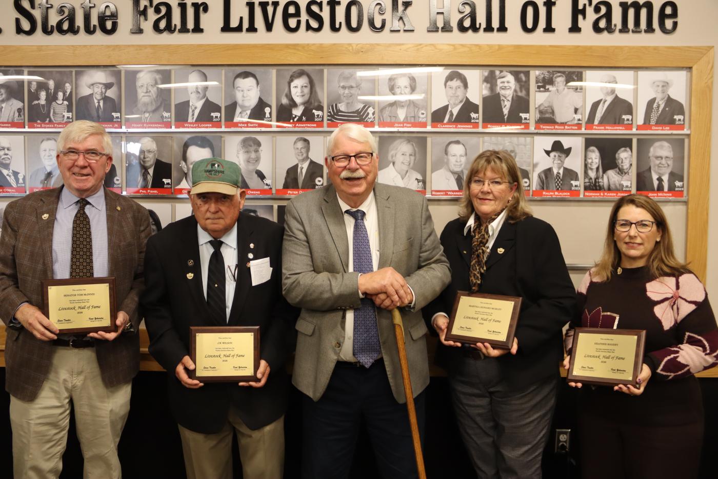 Three men and two women pose for a photo at the induction ceremony.