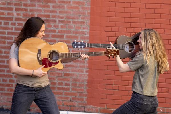 Two Girls Aiming Guitars at Each Other 