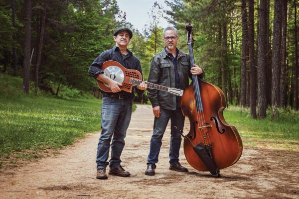 Two men holding instruments on a path