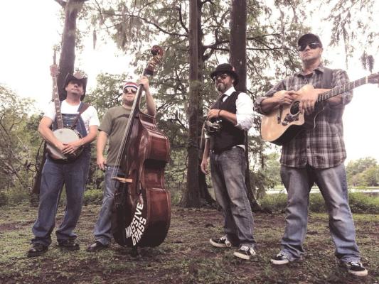 Band of four men standing in the woods 