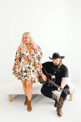 Woman standing with Man playing guitar 
