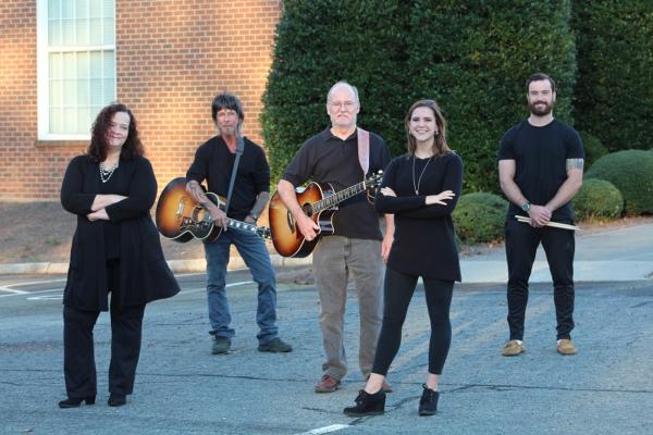 Group of friends with instruments in front of building