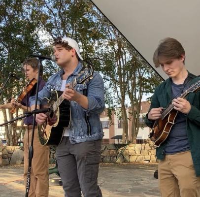 Three guys playing instruments and singing