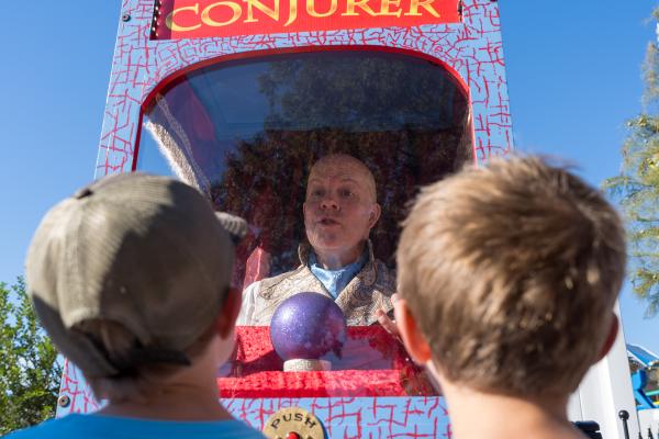 Two young kids getting their fortune from the Conjurer