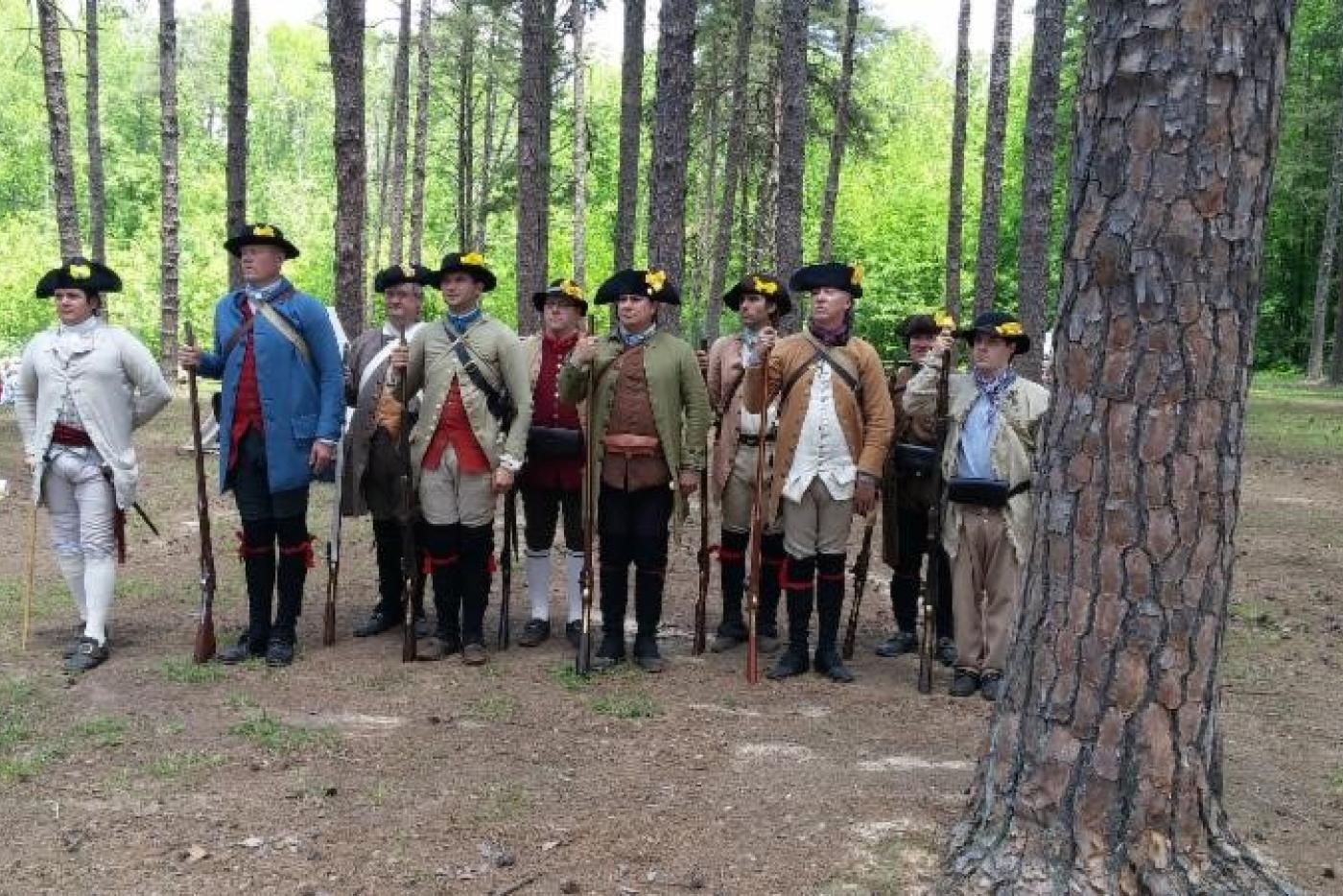 A lineup of historical interpreters dressed as Revolution era soldiers.