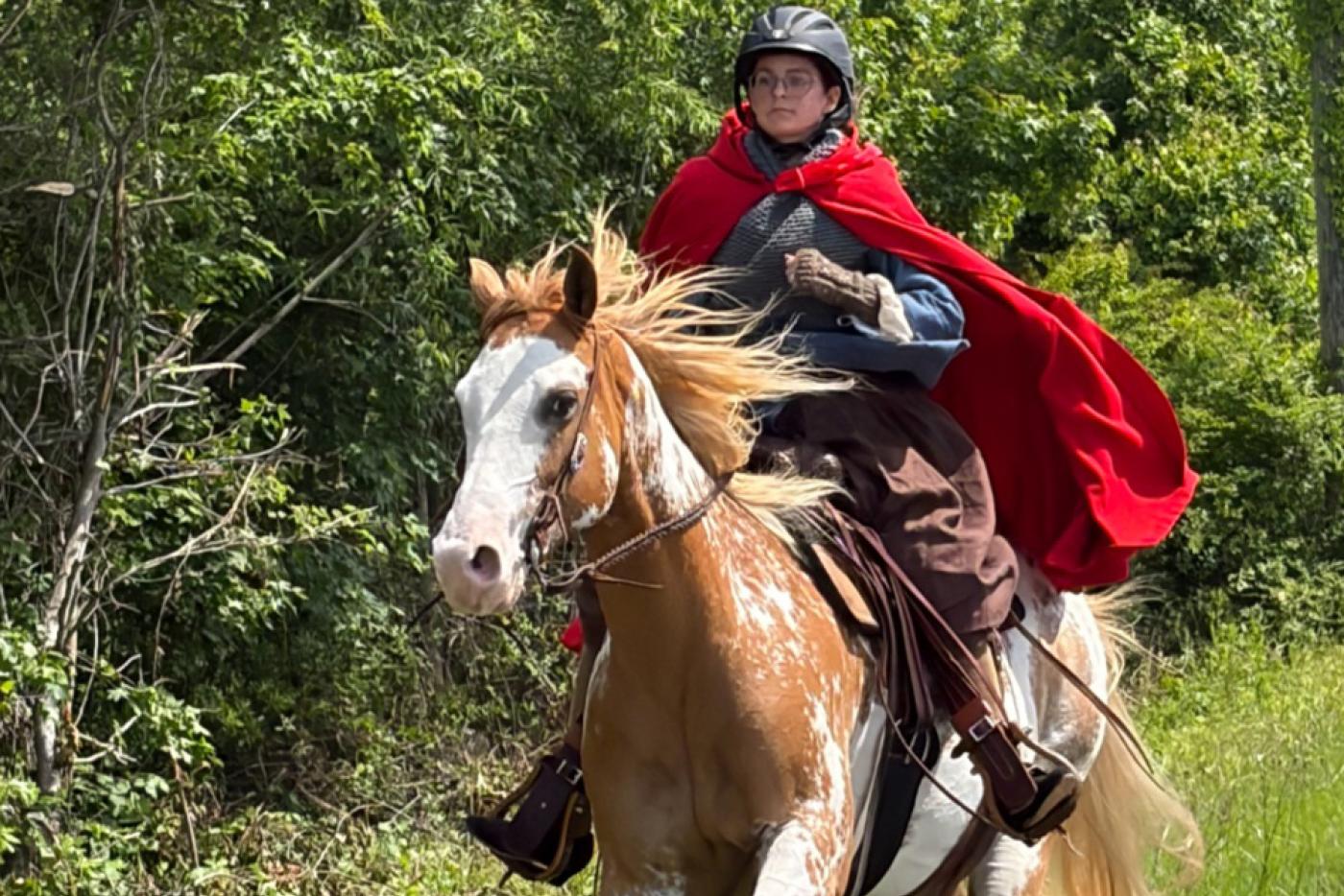 lady rides a horse with greenery in the background