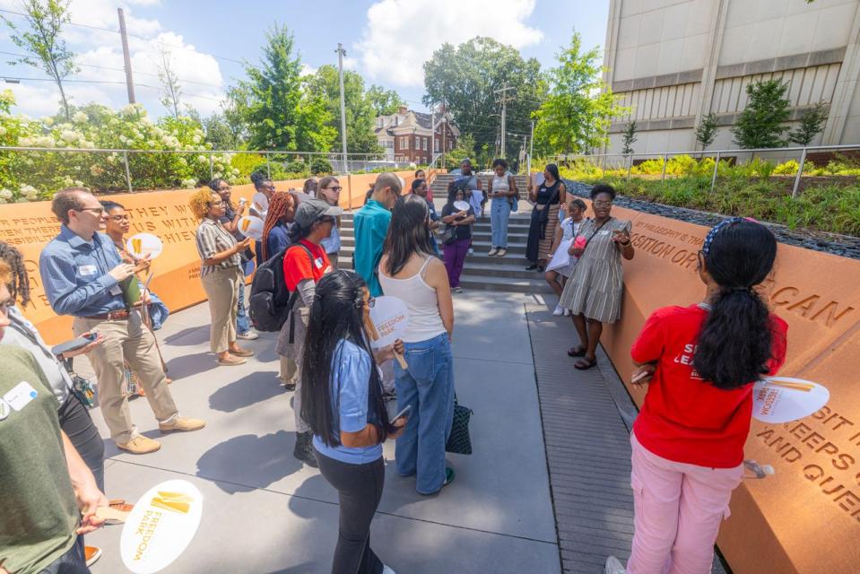 Group of people standing outside around a memorial
