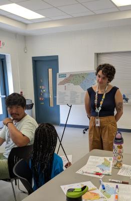 Two team members listen as a young camper asks a question