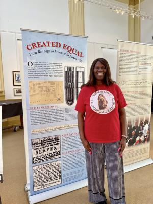 Woman stands in front of exhibit panel
