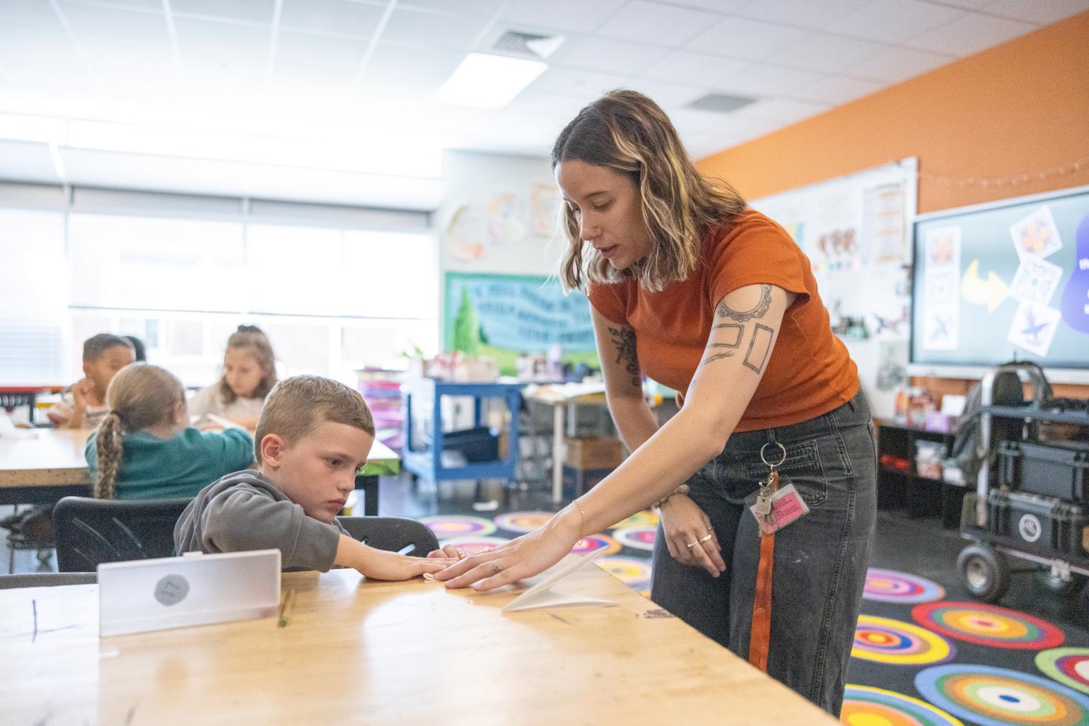 Teacher guiding a student in an arts classroom
