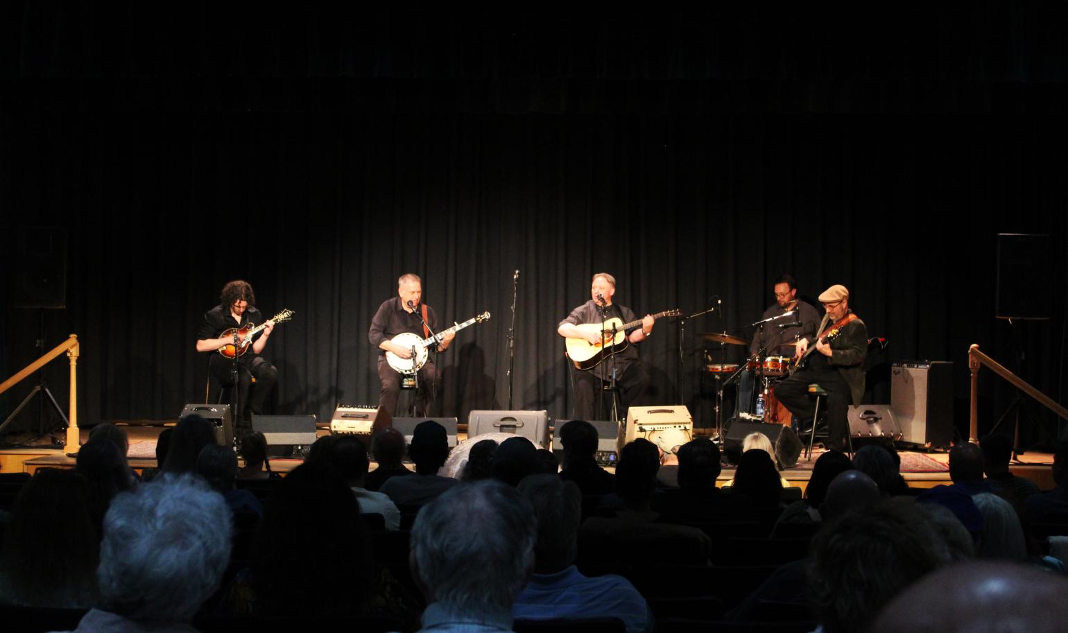 Musicians performing on stage. The Kruger Brothers at the Museum of the Albemarle