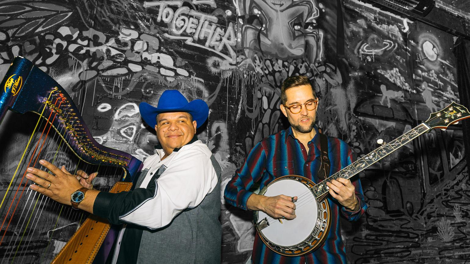 Musicians Larry and Joe playing their instruments, a harp and a banjo