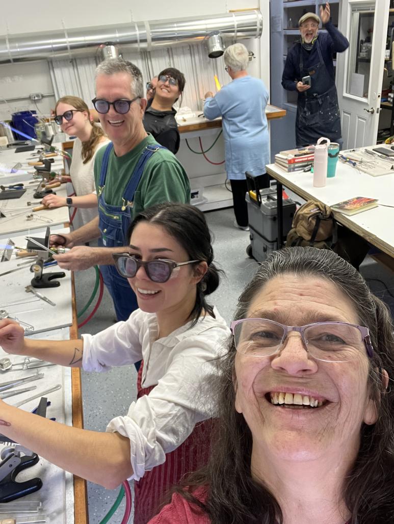 Instructor and students working in studio on lampwork.