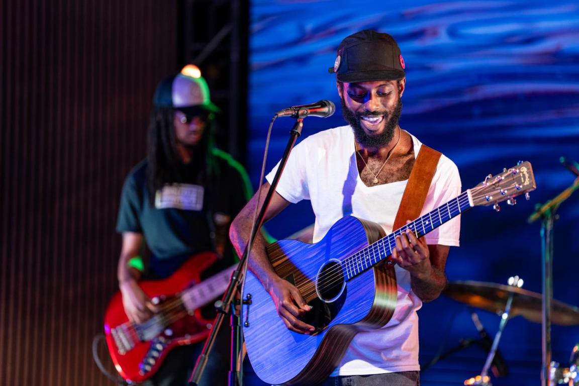 Sonny Miles plays acoustic guitar backed by a electric bassist