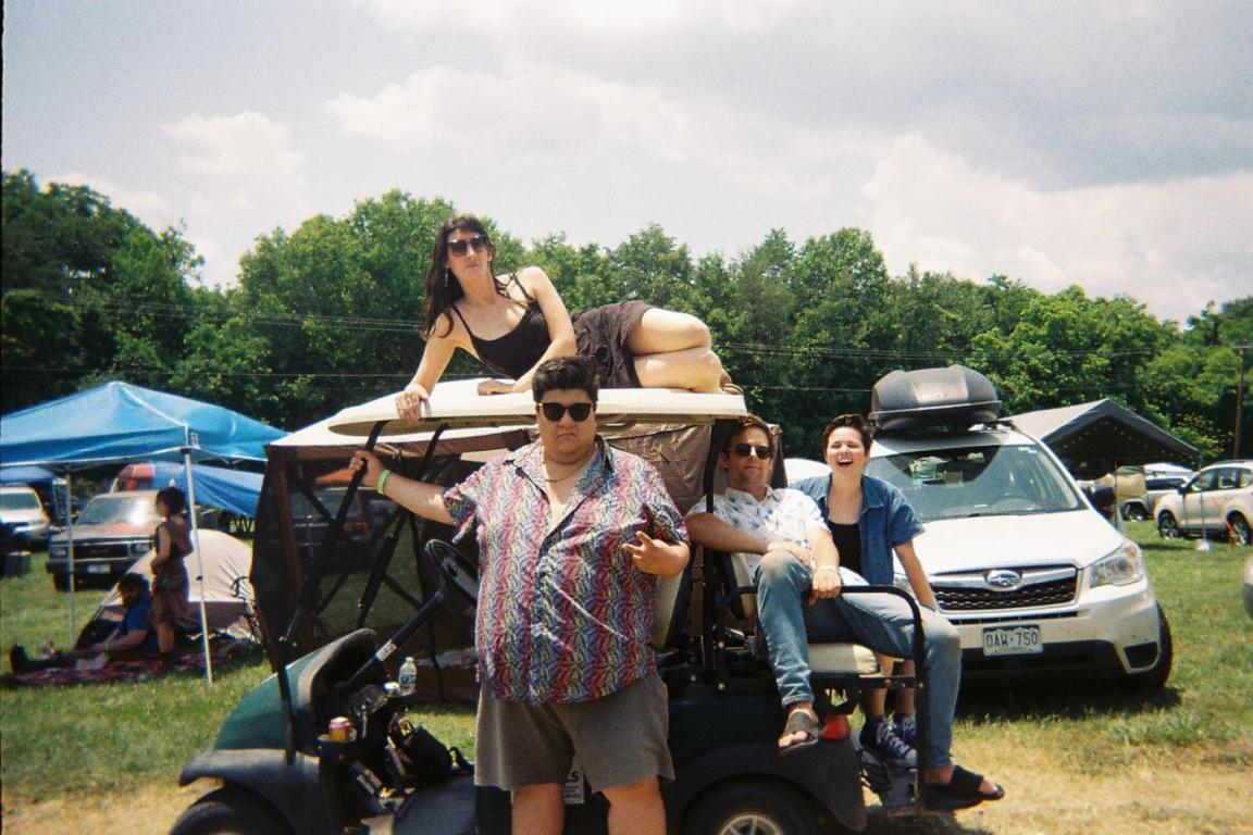 Hard Drive, four-member group, pose for a candid color photo atop a gold cart