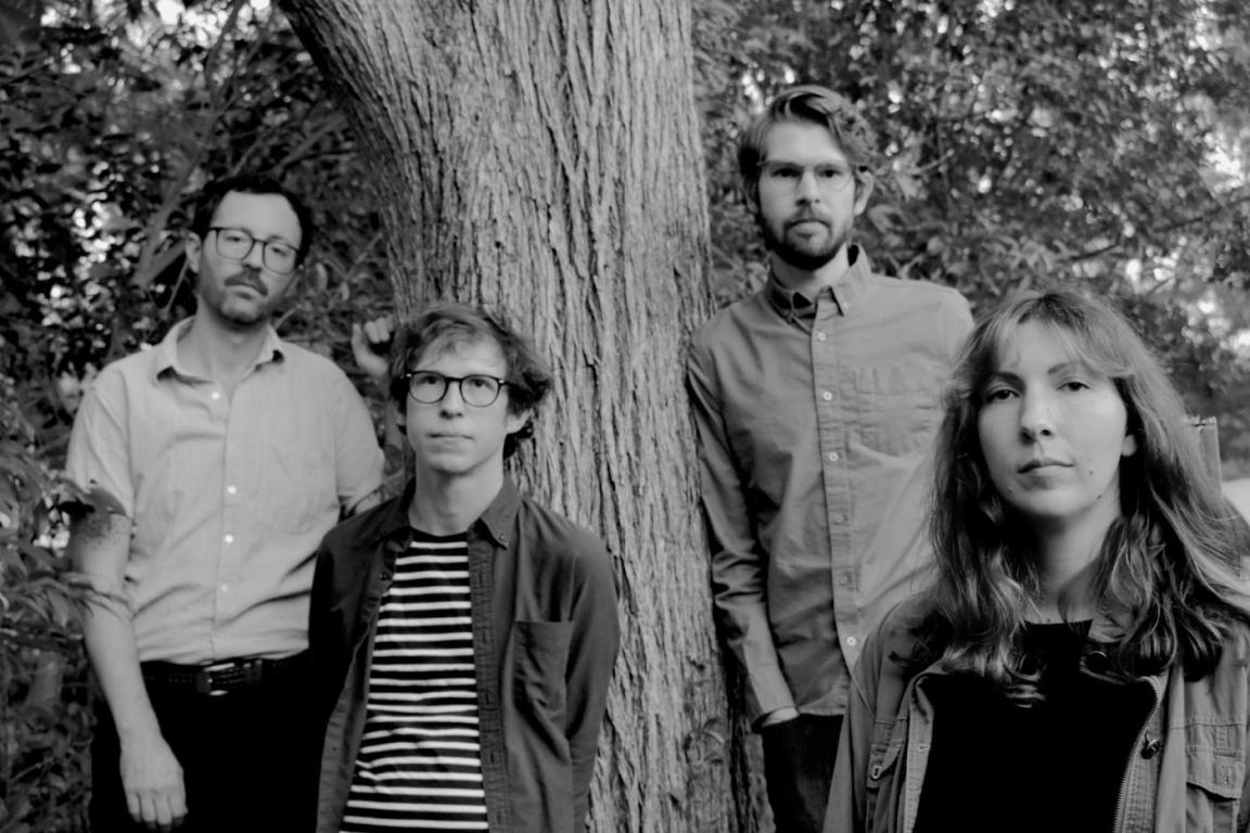 the band Verity Den, a four-piece, standing in front of a tree in a black-and-white photo