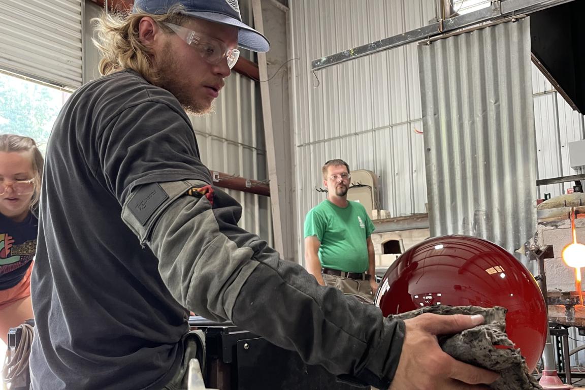 Dillsboro Creative Art Center glass artist, Cole Johnson, working on round glass ball. Courtesy of JCGEP and DCAC