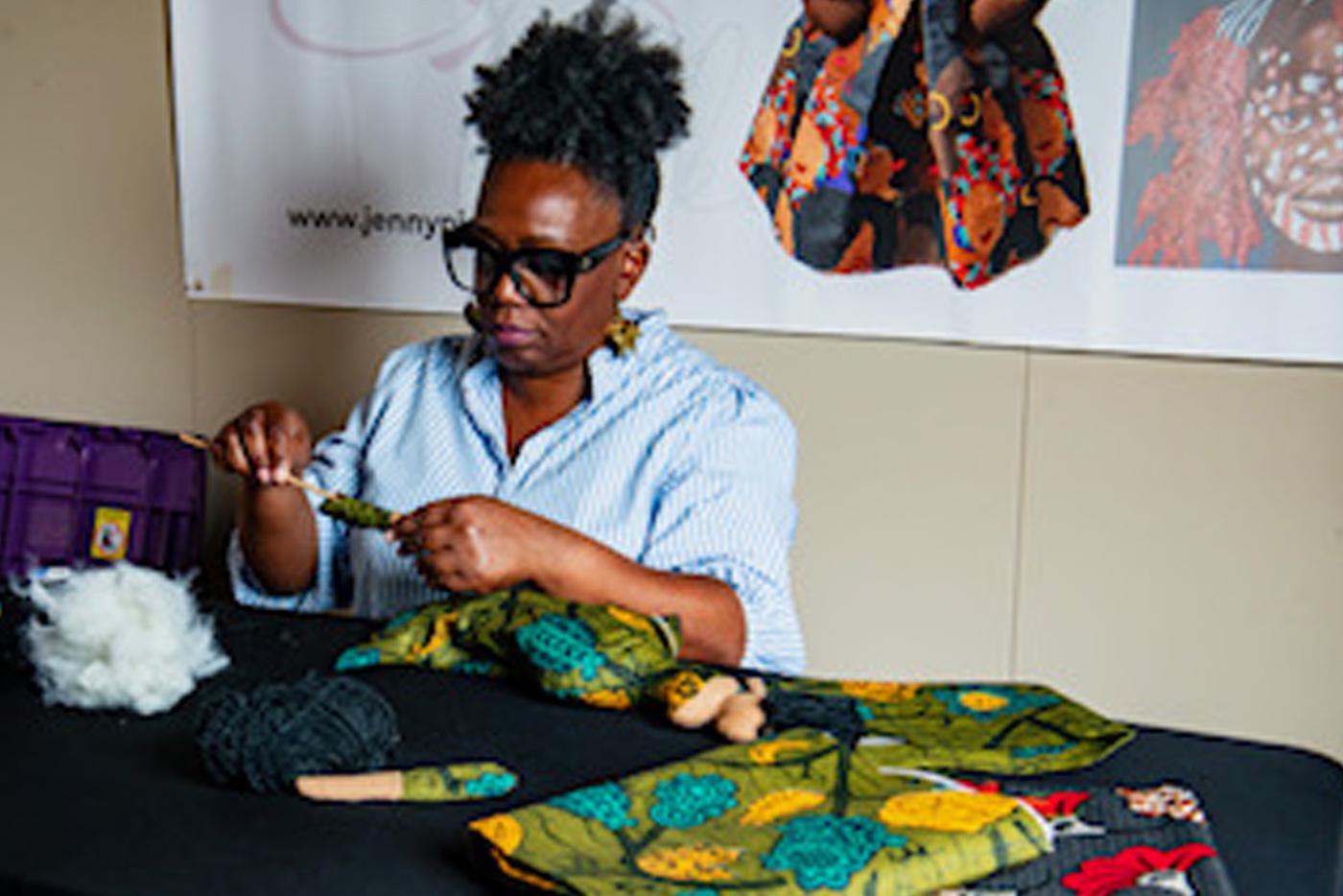 Jenny Pickens works on a handcrafted doll. Photo by Chris Moser