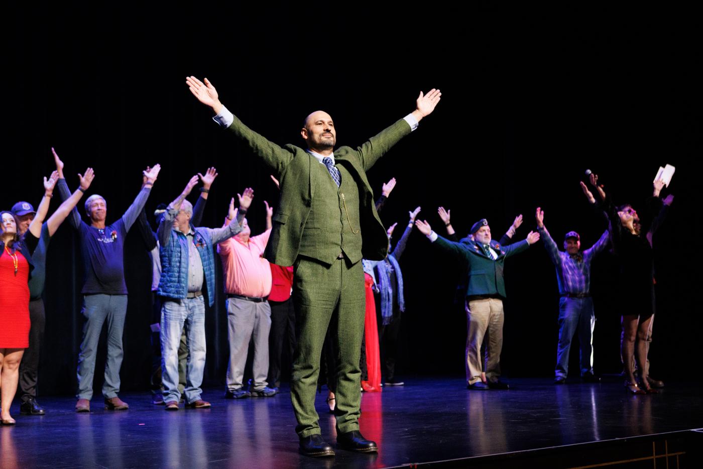 U.S. Army veteran Alfredo Hurtado leads members of Black Box Dance Theatre and Brothers and Sisters Like These in signing ‘Show Up’ at the Community First premiere of We Lift Each Other in Asheville