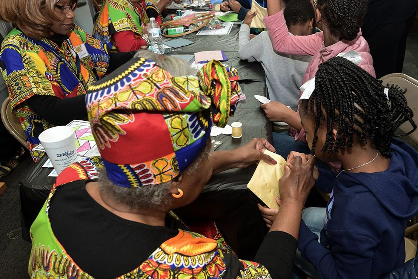 Volunteers help children with craft at 19th Annual African American Cultural Celebration in 2020. Photo by Eric Blevins, courtesy of the N.C. DNCR 