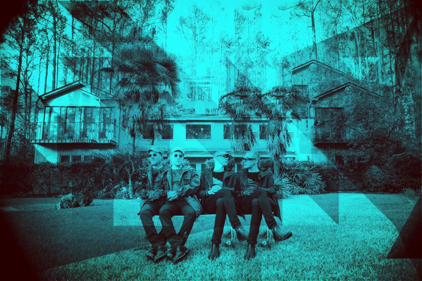 The two members of Tescon Pol sit on a bench in a fractalized and blue tinted portrait 