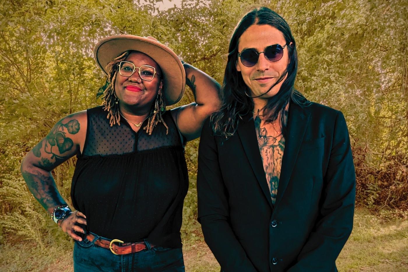 Moonshine State, a duo, stand in front of yellowish-green foliage