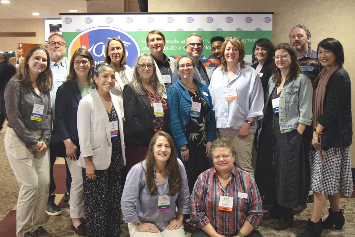 A group of people in front of an ARTS Day step and repeat banner.