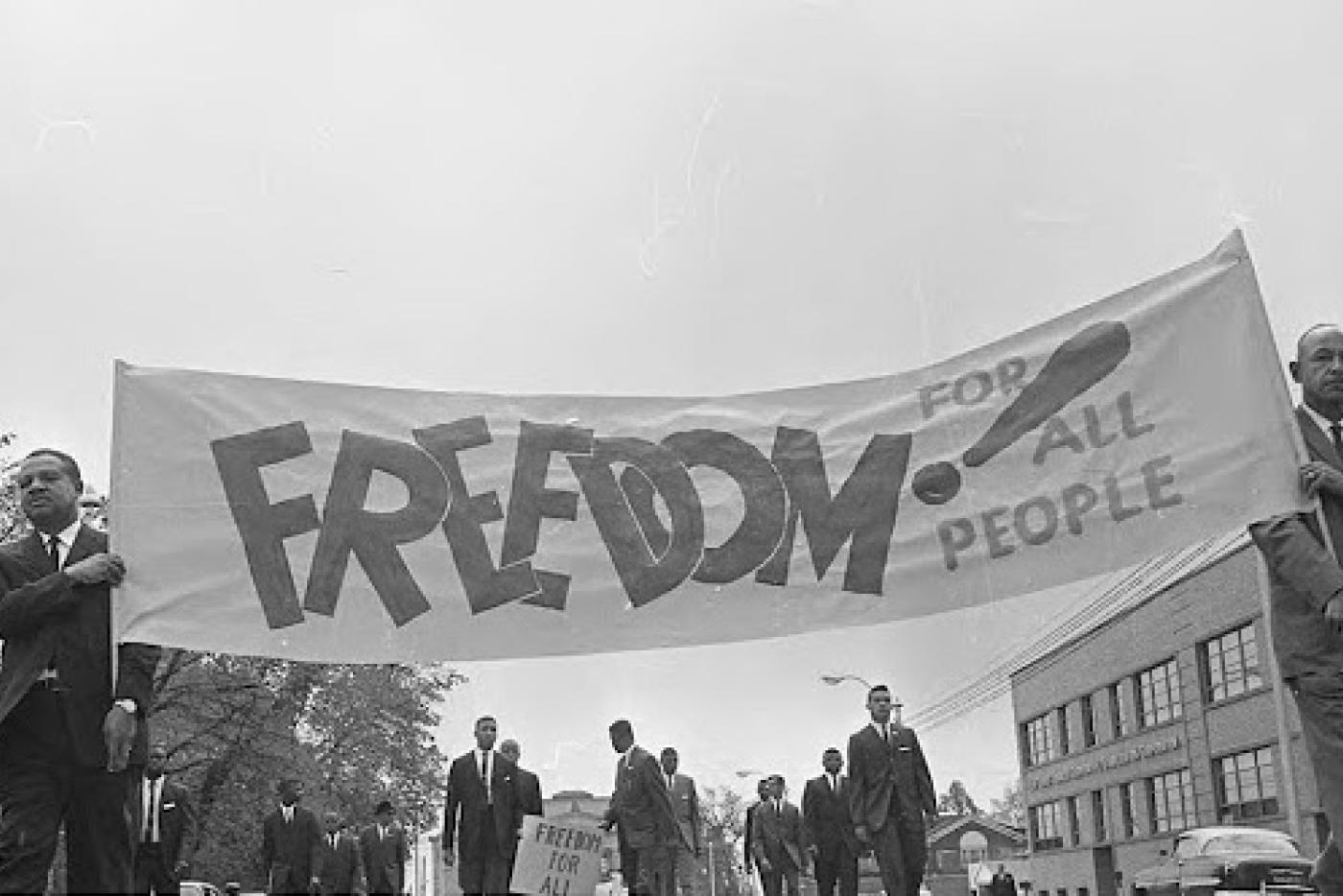 Men from 1963 carrying a sign saying "Freedom for All People" from the News and Observer Negative Collection