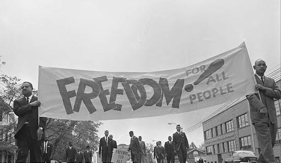 Men from 1963 carrying a sign saying "Freedom for All People" from the News and Observer Negative Collection