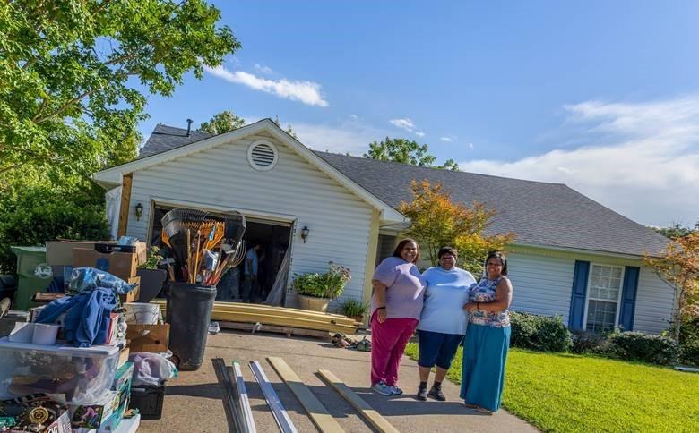 Homeowner Matalene Waters and her family standing in front of her recently repaired home
