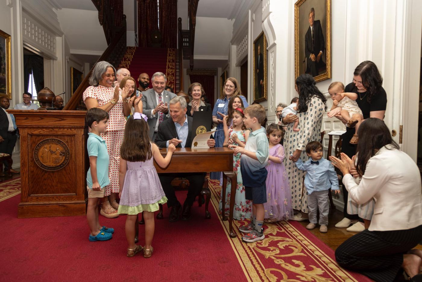 Governor Stein presents a proclamation celebrating Child Care Provider Appreciation Day, joined at the Governor's Mansion with child care workers.