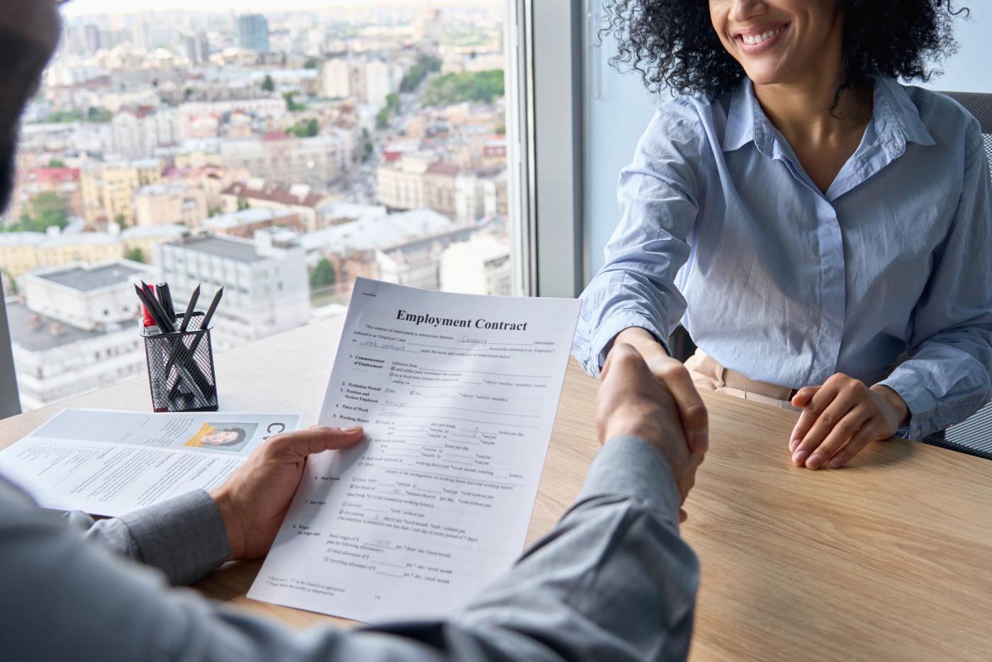 ceo holding employment contract job offer hiring welcoming newcomer worker manager shaking hands in contemporary office. Human resources concept