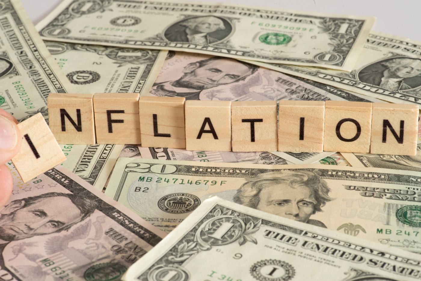 image with the word inflation written in blocks on top of cash
