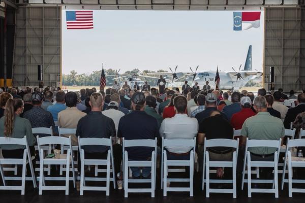 Attendees sit in an aircraft hangar for the ribbon cutting of the U.S. Navy’s Fleet Readiness Center East.