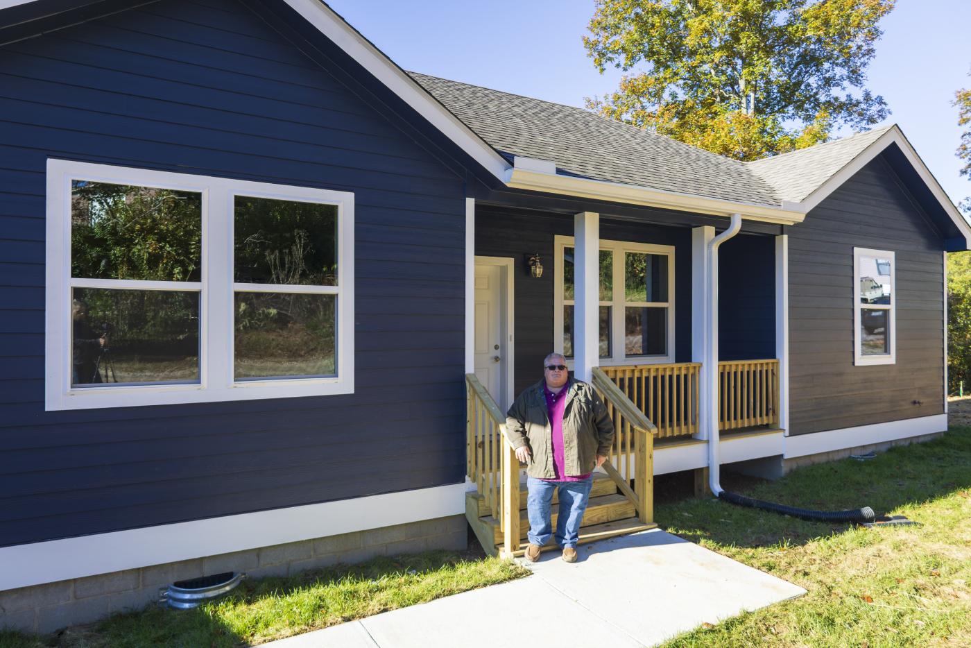 man standing in front of home