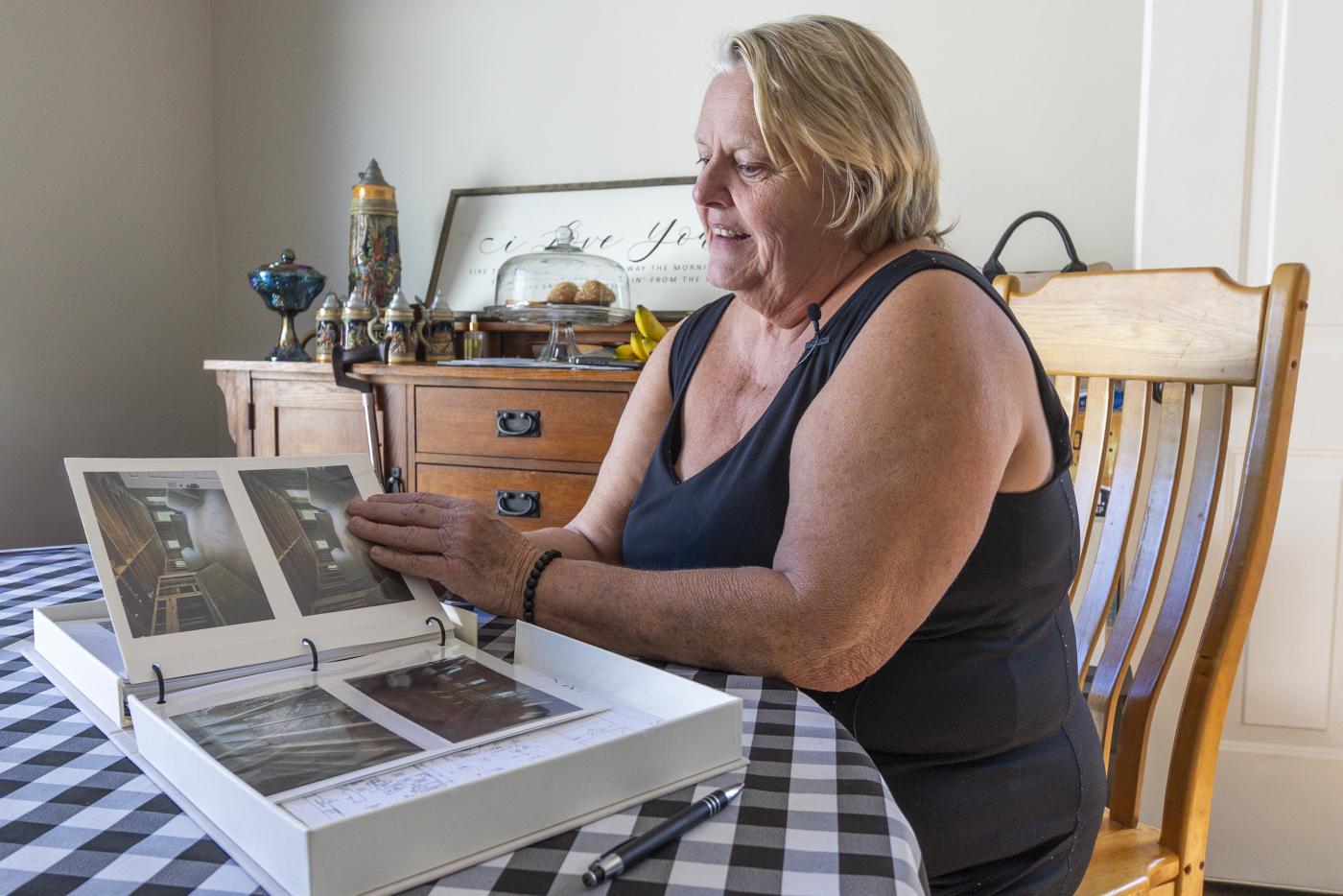 woman seated at table looking at photo album